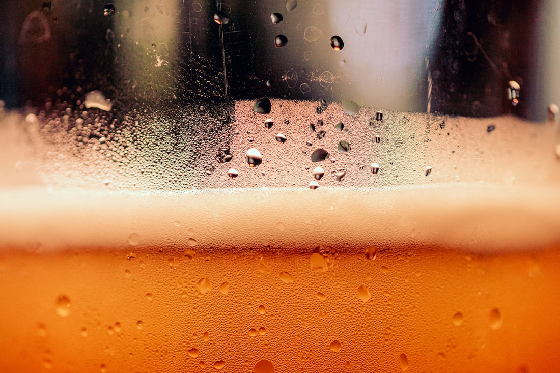 Dark oatmeal stout in a glass with a creamy tan head and velvety appearance
